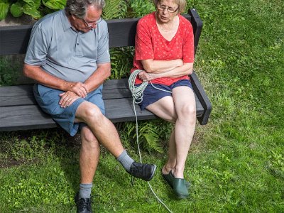 Samtal på bänk  Ted van Heesch och Kristina i samtal 19 juli medan katten Rulle kollar in fotografen.