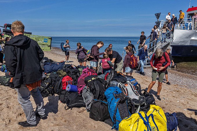Bagagehög på stranden Ryggsäckar, bagar, sovsäckar med mera i en enda hög på land.
