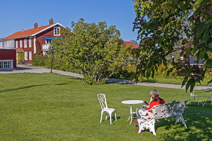 Järvsöbaden Kristina kollar e-posten på en soffa i trädgården.