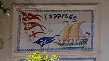 Kommunflaggor Skylt ovan fiskeresresturang i Minori med flaggor för de olika kommunerna längs kusten. Längst ned Amalafi.