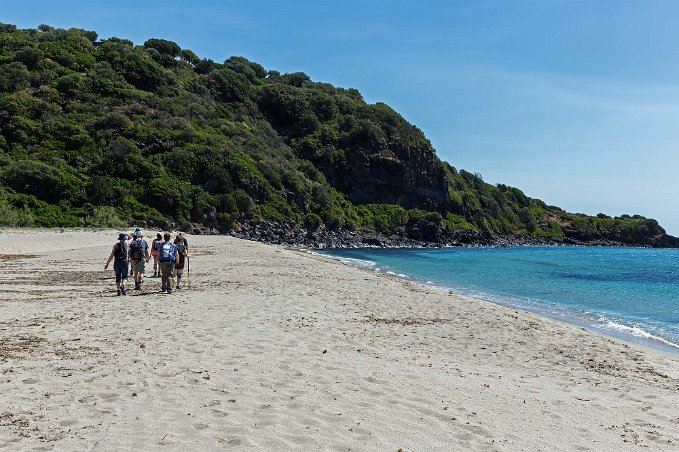 Stranden Cala Cartoe Sandpulsande upp mot stigen längs stranden.